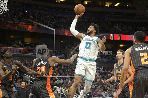 Charlotte Hornets forward Miles Bridges (0) goes up for a shot between Orlando Magic center Mo Bamba (5), center Wendell Carter Jr. (34), forward Franz Wagner (22) and guard Mychal Mulder (2) during the first half of an NBA basketball game, Wednesday, Nov. 24, 2021, in Orlando, Fla. (AP Photo/Phelan M. Ebenhack)