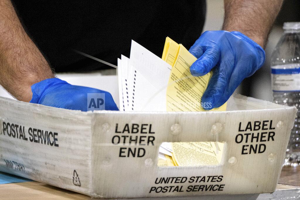 Ben Gray Fulton County Georgia elections workers process absentee ballots for the Senate runoff election in Atlanta on Tuesday, Jan. 5, 2021. Georgia's two Senate runoff elections on Tuesday will determine which party controls the U.S. Senate. Republican Kelly Loeffler is going up against Democrat Raphael Warnock, while Republican David Perdue is challenging Democrat Jon Ossoff. Democrats must win both seats to take control of the Senate. (AP Photo/Ben Gray)