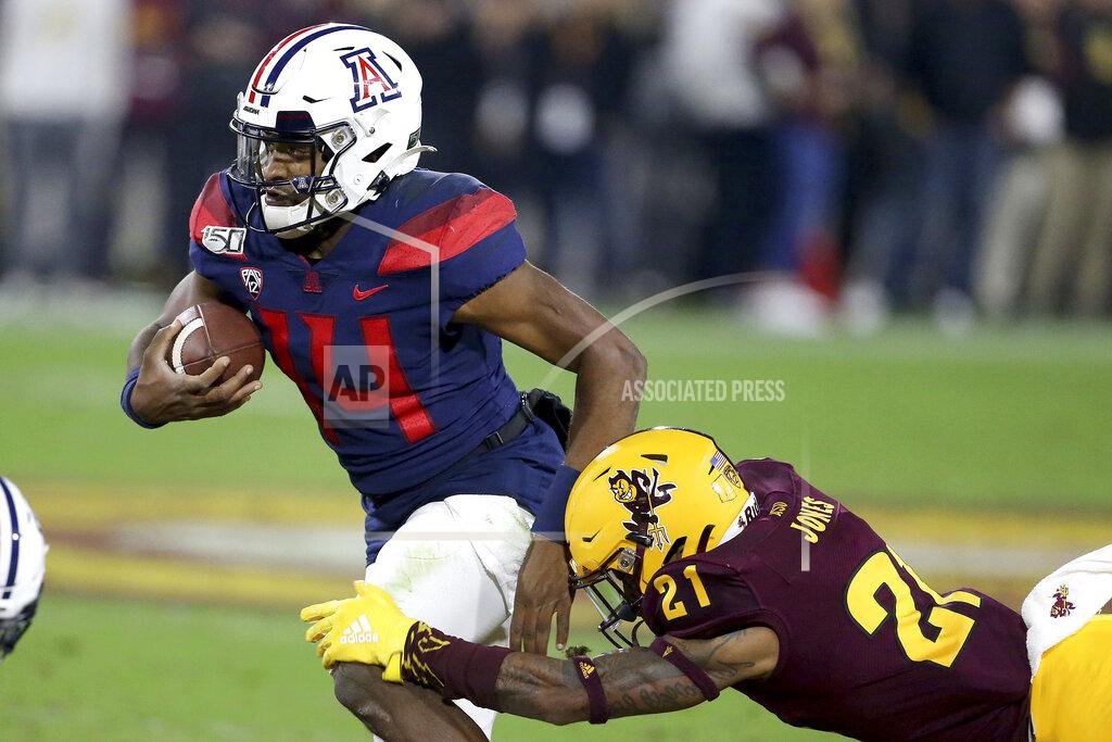 Darryl Webb Arizona's Khalil Tate (14) slips the tackle of Arizona State's Jack Jones (21) during the first half of an NCAA college football game, Saturday, Nov. 30, 2019, in Tempe, Ariz. (AP Photo/Darryl Webb)