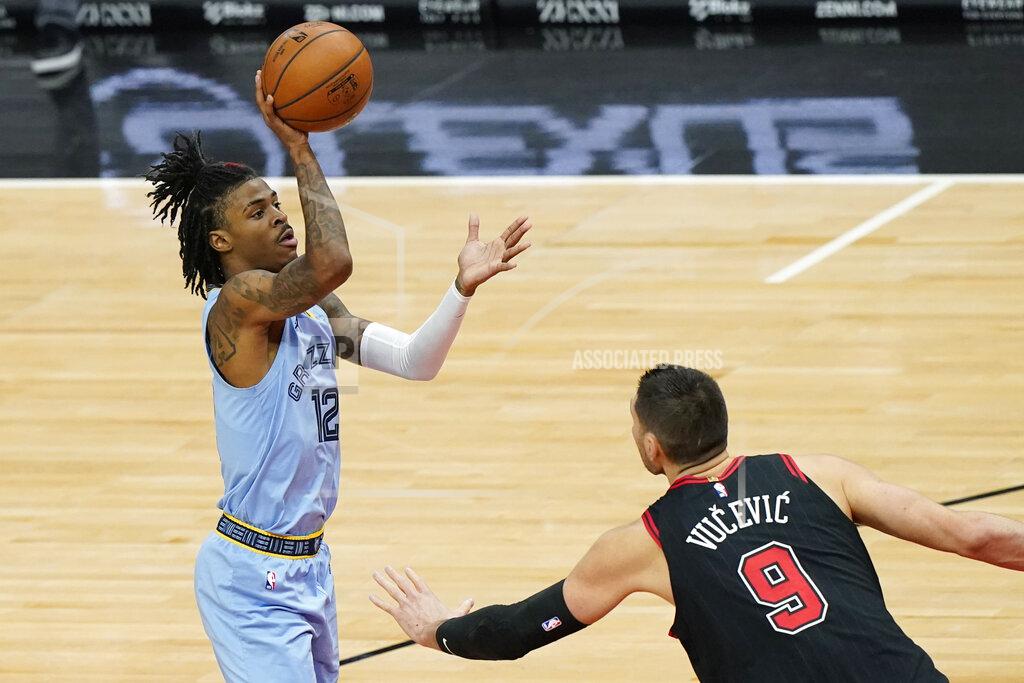 Nam Y. Huh Memphis Grizzlies guard Ja Morant, left, shoots as Chicago Bulls center Nikola Vucevic defends during the first half of an NBA basketball game in Chicago, Friday, April 16, 2021. (AP Photo/Nam Y. Huh)