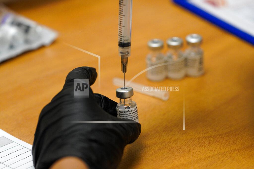 Nelvin C. Cepeda A Scripps health official draws from a vile of the COVID-19 vaccine prior to administering it at their new drive-thru vaccination site at the Del Mar Fairgrounds on Friday, Feb. 12, 2021, in Del Mar, Calif. (Nelvin C. Cepeda/The San Diego Union-Tribune via AP, Pool)