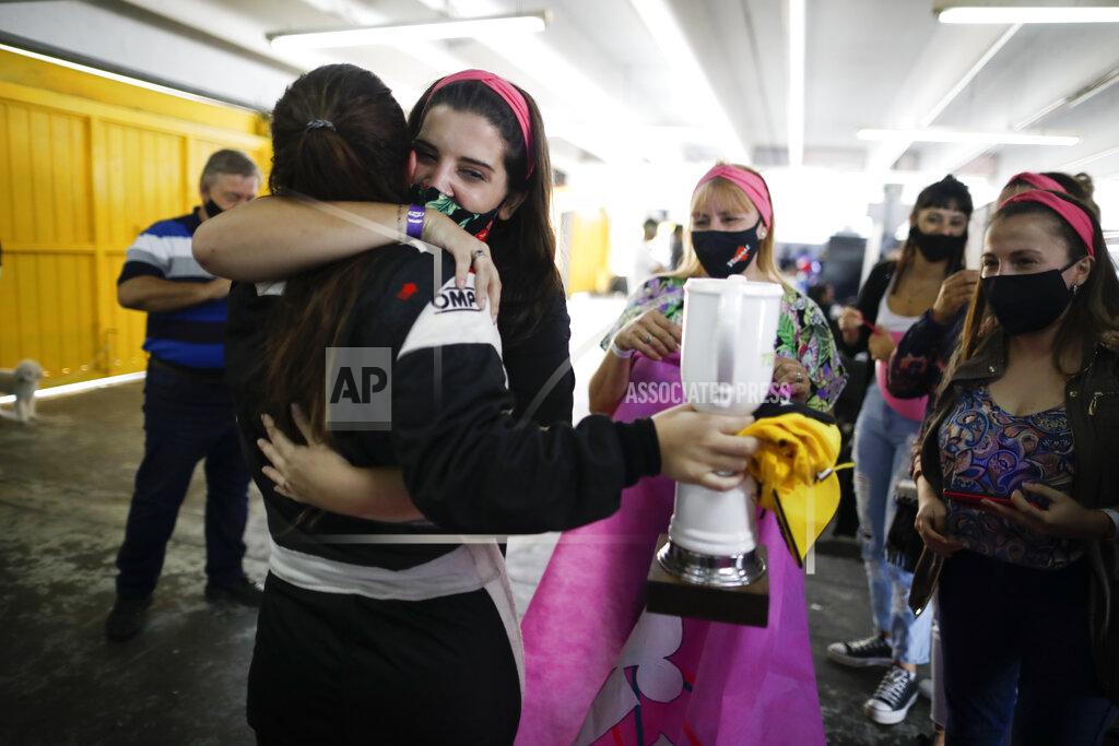 Natacha Pisarenko Vitarti Girl’s Team driver Rocio Migliore, back to camera, arrives at pits and is embraced by friends to celebrate her second-place finish at the Oscar y Juan Galvez track in Buenos Aires, Argentina, Sunday, April 4, 2021. The racing team exclusive to females took part in the Top Race Junior series, a national competition, in Argentina for the first time. (AP Photo/Natacha Pisarenko)