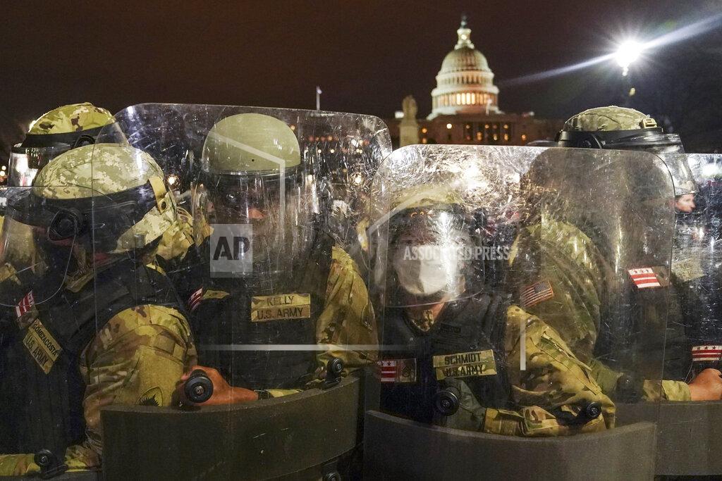 John Minchillo DC National Guard stand outside the Capitol, Wednesday night, Jan. 6, 2021, after a day of rioting protesters. It's been a stunning day as a number of lawmakers and then the mob of protesters tried to overturn America's presidential election, undercut the nation's democracy and keep Democrat Joe Biden from replacing Trump in the White House. (AP Photo/John Minchillo)
