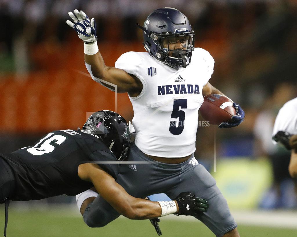 Marco Garcia Nevada running back Jaxson Kincaide (5) gets tackled by Hawaii defensive back Kalen Hicks (16)during the second quarter of an NCAA college football game, Saturday, Oct. 20, 2018, in Honolulu. (AP Photo/Marco Garcia)