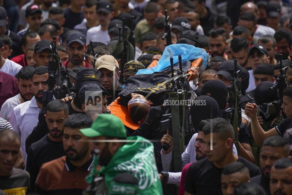 Majdi Mohammed Palestinian mourners, some armed, carry the body of Amjad al-Fayyed, 17, during his funeral in the West Bank refugee camp of Jenin, Saturday, May 21, 2022. Israeli troops shot and killed al-Fayyed as fighting erupted when soldiers entered a volatile town in the occupied West Bank early Saturday, the Palestinian health ministry and local media said. (AP Photo/Majdi Mohammed)
