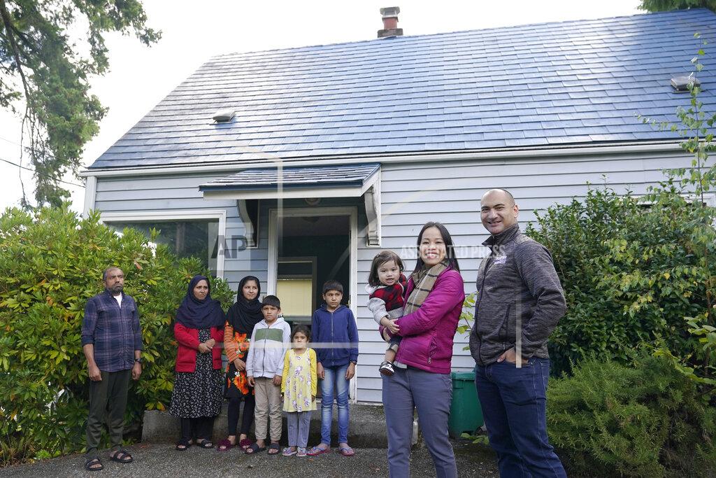 Ted S. Warren Thuy Do, second from right, poses for a photo with her husband, Jesse Robbins, right, and their son, Fredrick, Monday, Sept. 20, 2021. Do was nine years old when her family arrived in the United States from Vietnam in the 1980s, and that memory led Do and Robbins to reach out to assist Afghans fleeing their country. (AP Photo/Ted S. Warren)