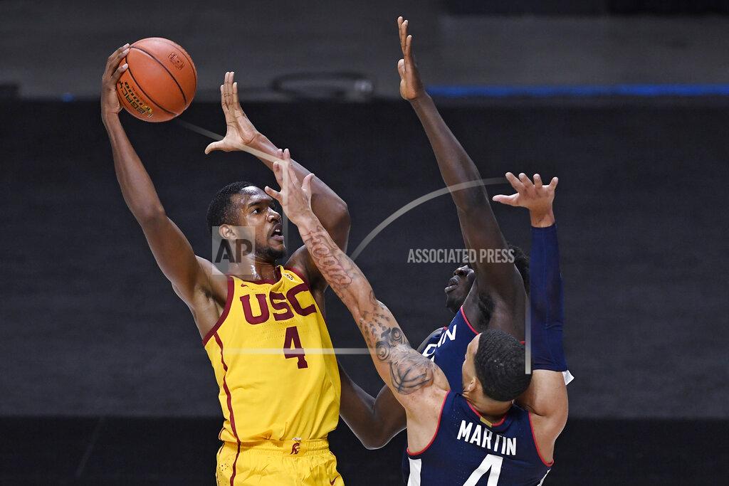 Jessica Hill Southern California's Evan Mobley shoots over Connecticut's Tyrese Martin, front, and Adama Sanogo during the second half of an NCAA college basketball game Thursday, Dec. 3, 2020, in Uncasville, Conn. (AP Photo/Jessica Hill)