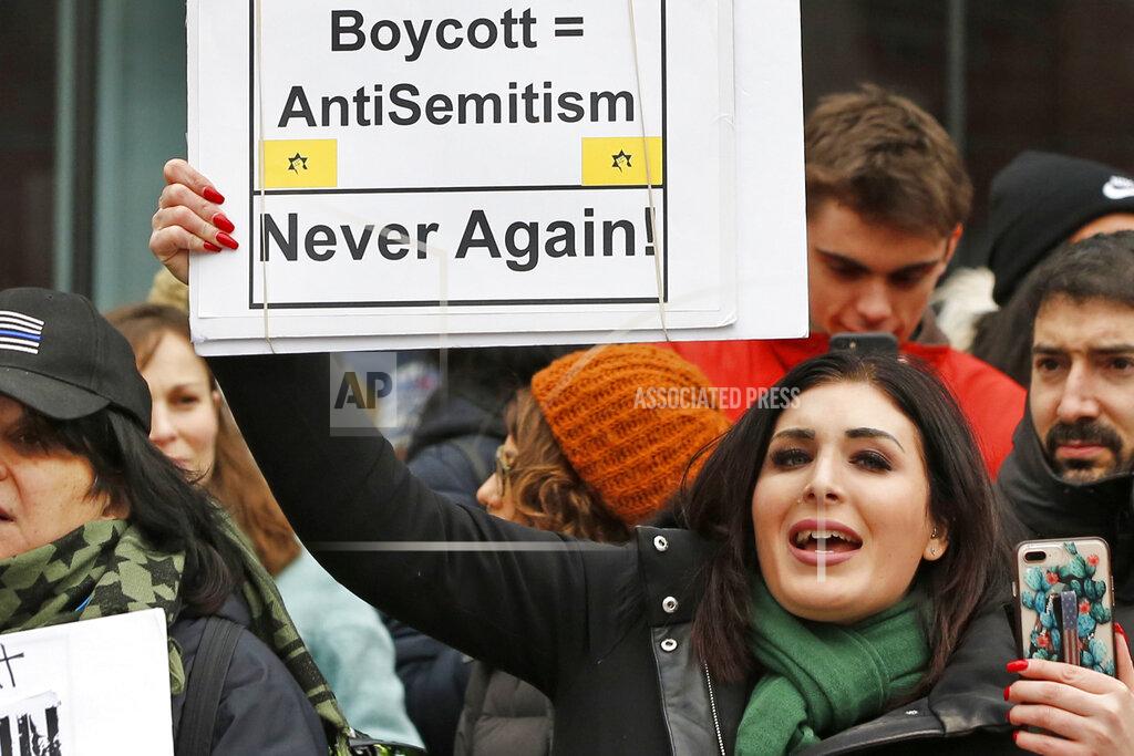 FILE - In this Jan. 19, 2019, file photo, political activist Laura Loomer holds up a sign across the street from a rally organized by Women's March NYC after she barged onto the stage interrupting Women's March NYC director Agunda Okeyo who was speaking during a rally in New York. Loomer, a far-right social media provocateur whose hate speech got her banned from social media won her Republican primary on Tuesday, Aug. 18, 2020, and will challenge Democratic Rep. Lois Frankel for Congress in November. (AP Photo/Kathy Willens, File)