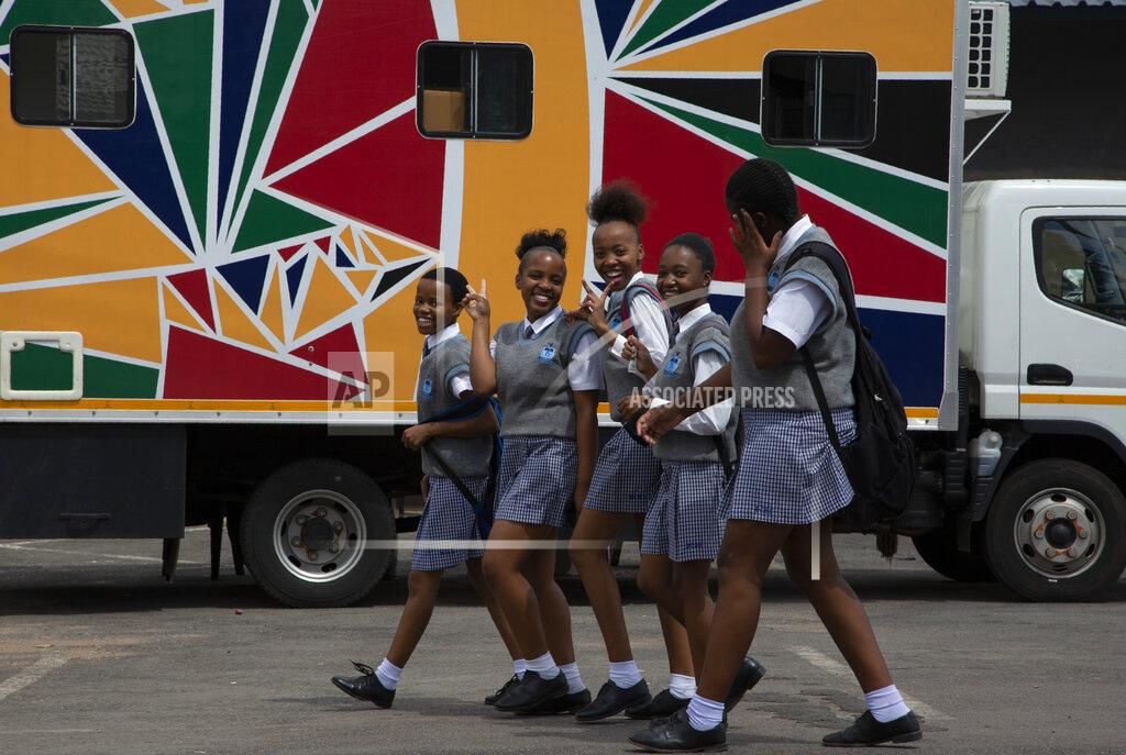 Denis Farrell Schoolgirls pass a mobile clinic, background, run by the Reproductive Health and HIV Institute (RHI) in the Soshanguve Township, north of Pretoria, South Africa, Thursday, Nov. 26 2020. The successful trials of a new injectable drug that needs to be taken every eight weeks to prevent HIV infection is being lauded on World AIDS Day as a turning point for the fight against a global health threat that's been eclipsed by the coronavirus pandemic. (AP Photo/Denis Farrell)