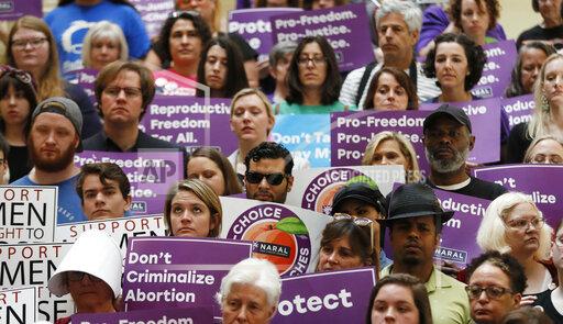 FILE - In this May 16, 2019 file photo, abortion rights supporters stand during a news conference by Presidential candidate Sen. Kirsten Gillibrand, D-N.Y., at the Georgia State Capitol in Atlanta to discuss abortion bans in Georgia and across the country. A federal appeals court plans to hear arguments Friday, Sept. 24, 2021 on whether it should overturn a lower court’s ruling that permanently blocks a restrictive abortion law passed in 2019 by Georgia lawmakers. (Bob Andres/Atlanta Journal-Constitution via AP)