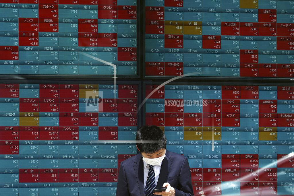 Eugene Hoshiko A man wearing a protective mask stands in front of an electronic stock board showing Japan's Nikkei 225 index at a securities firm Wednesday, May 26, 2021, in Tokyo. Asian stock markets rose Wednesday as inflation fears eased and investors looked ahead to U.S. data that are expected to show economic growth accelerating. (AP Photo/Eugene Hoshiko)