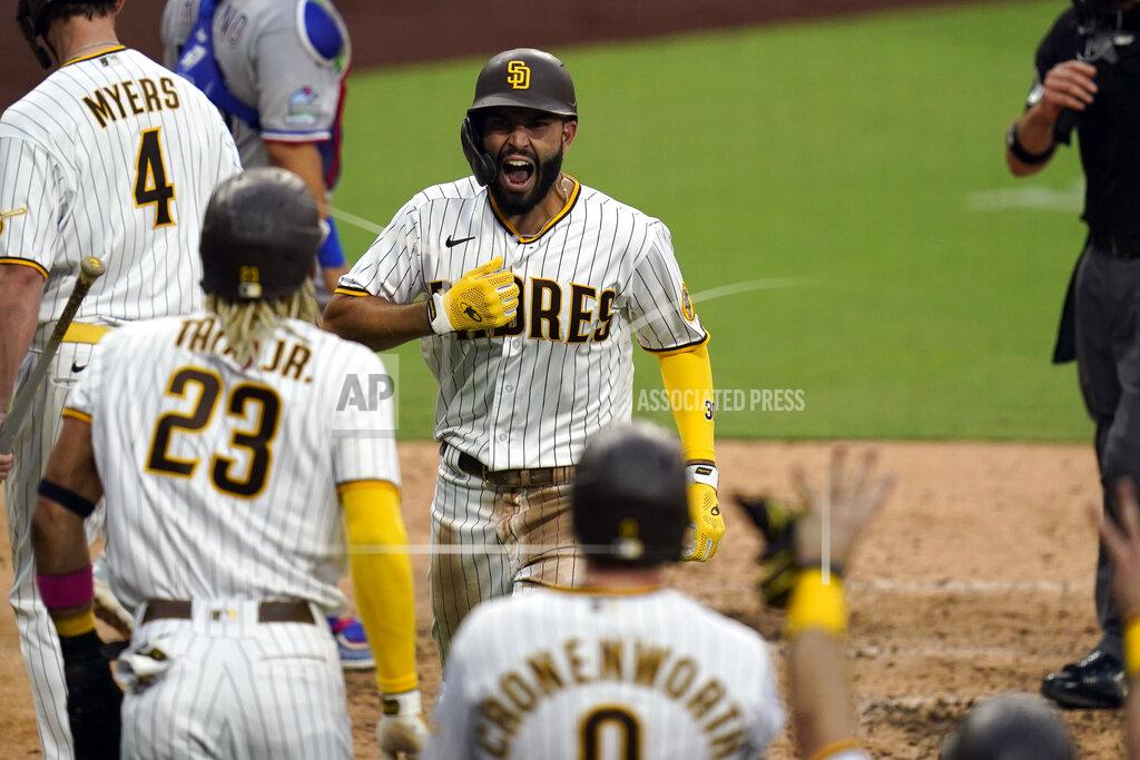 Gregory Bull San Diego Padres' Eric Hosmer, center, reacts with teammates after hitting a grand slam during the fifth inning of a baseball game against the Texas Rangers, Thursday, Aug. 20, 2020, in San Diego. (AP Photo/Gregory Bull)