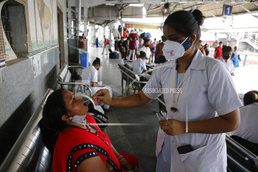 Ajit Solanki A health worker takes a swab sample of a passenger entering the city to test for COVID-19, at a railway station in Ahmedabad, India, Friday, July 23, 2021. (AP Photo/Ajit Solanki)