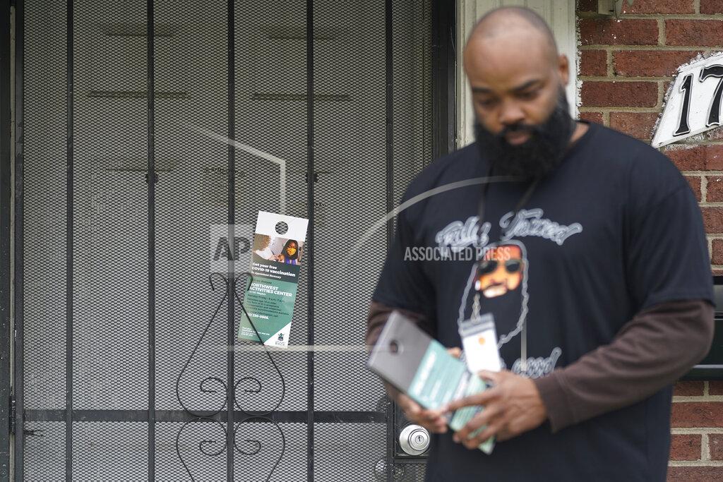 Paul Sancya Anthony Brinson leaves a flyer on a home in Detroit, Tuesday, May 4, 2021. Officials are walking door-to-door to encourage residents of the majority Black city to get vaccinated against COVID-19 as the city's immunization rate lags well behind the rest of Michigan and the United States. (AP Photo/Paul Sancya)
