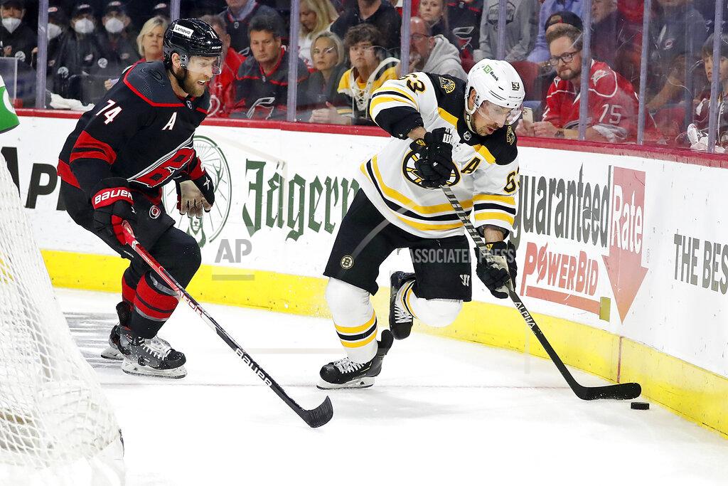 Karl B Deblaker Boston Bruins' Brad Marchand (63) controls the puck as Carolina Hurricanes' Jaccob Slavin (74) skates in during the first period of Game 7 of an NHL hockey Stanley Cup first-round playoff series in Raleigh, N.C., Saturday, May 14, 2022. (AP Photo/Karl B DeBlaker)