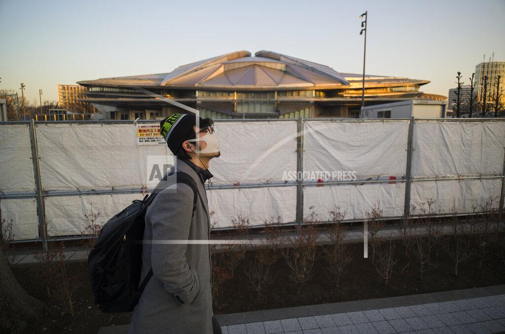 Hiro Komae A man walks past the closed Tokyo Metropolitan Gymnasium, a venue renovated to be used in the rescheduled Tokyo Olympics, in Tokyo on Thursday, Jan. 21, 2021. The arena was used for the Tokyo 1964 Olympics. The postponed Tokyo Olympics are to open in just six months. Local organizers and the International Olympic Committee say they will go ahead on July 23. But it’s still unclear how this will happen with virus cases surging in Tokyo and elsewhere around the globe. (AP Photo/Hiro Komae)