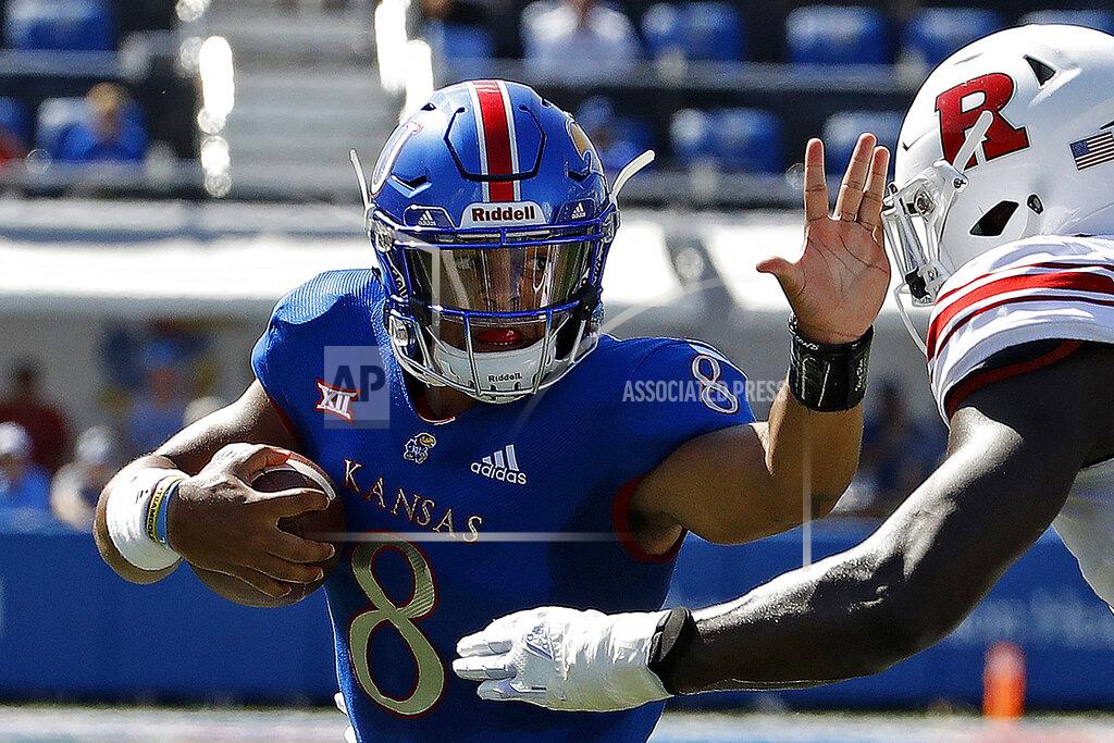 Charlie Riedel FILE - In this Sept. 15, 2018, file photo, Kansas quarterback Miles Kendrick (8) runs under pressure from Rutgers defensive lineman Elorm Lumor (7) during the first half of an NCAA college football game in Lawrence, Kan. Les Koenning has to be careful every time the new offensive coordinator at Kansas walks into one of the Jayhawks’ meeting rooms, making sure to address the right person by the right name. There’s Miles Kendrick and Miles Fallin, Manny Miles and Ben Miles. Throw in new coach Les Miles and you have miles and miles of Miles in Lawrence these days. (AP Photo/Charlie Riedel, File)