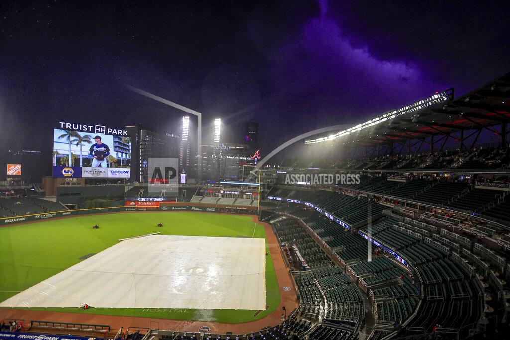 Butch Dill Play is stopped for a weather delay in the fifth inning of a baseball game between the Atlanta Braves and the St. Louis Cardinals, Monday, July 4, 2022, in Atlanta. (AP Photo/Butch Dill)