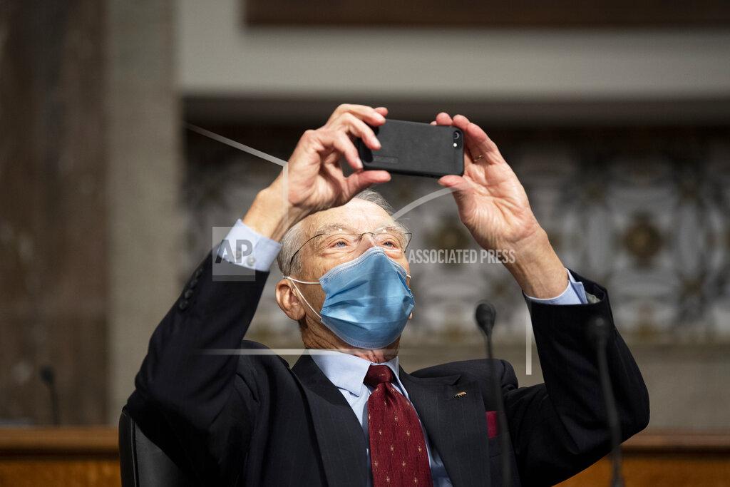 Caroline Brehman Sen. Chuck Grassley, R-Iowa, takes a cell phone photo of the empty Democratic Senators' seats on the Senate Judiciary Committee as they boycott the committee vote Thursday, Oct. 22, 2020, on Capitol Hill in Washington. (Caroline Brehman/Pool via AP)