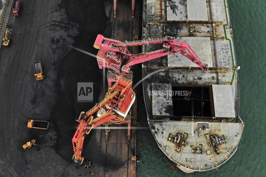 Wang Kai In this photo released by Xinhua News Agency, machines load imported coal from a cargo vessel docked at a port in Rizhao in east China's Shandong province on Nov. 21, 2019. Australia's prime minister said Tuesday, Dec. 15, 2020 that China would be in breach of World Trade Organization rules as well as a bilateral free trade agreement if it banned Australian coal. (Wang Kai/Xinhua via AP)