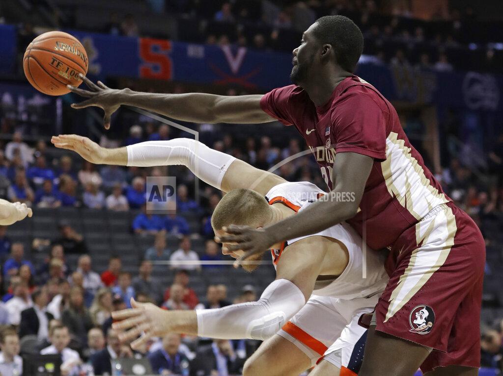 Nell Redmond Florida State's Christ Koumadje, top, knocks the ball from Virginia's Jack Salt, bottom, during the first half of an NCAA college basketball game in the Atlantic Coast Conference tournament in Charlotte, N.C., Friday, March 15, 2019. (AP Photo/Nell Redmond)