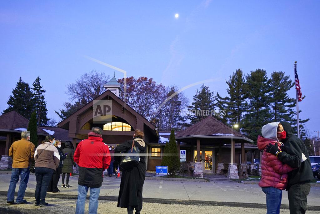 Tony Dejak A young couple waiting in line to vote hug outside of Adam Hall near Auburn Corners, Ohio, Tuesday, Nov. 3, 2020. (AP Photo/Tony Dejak)