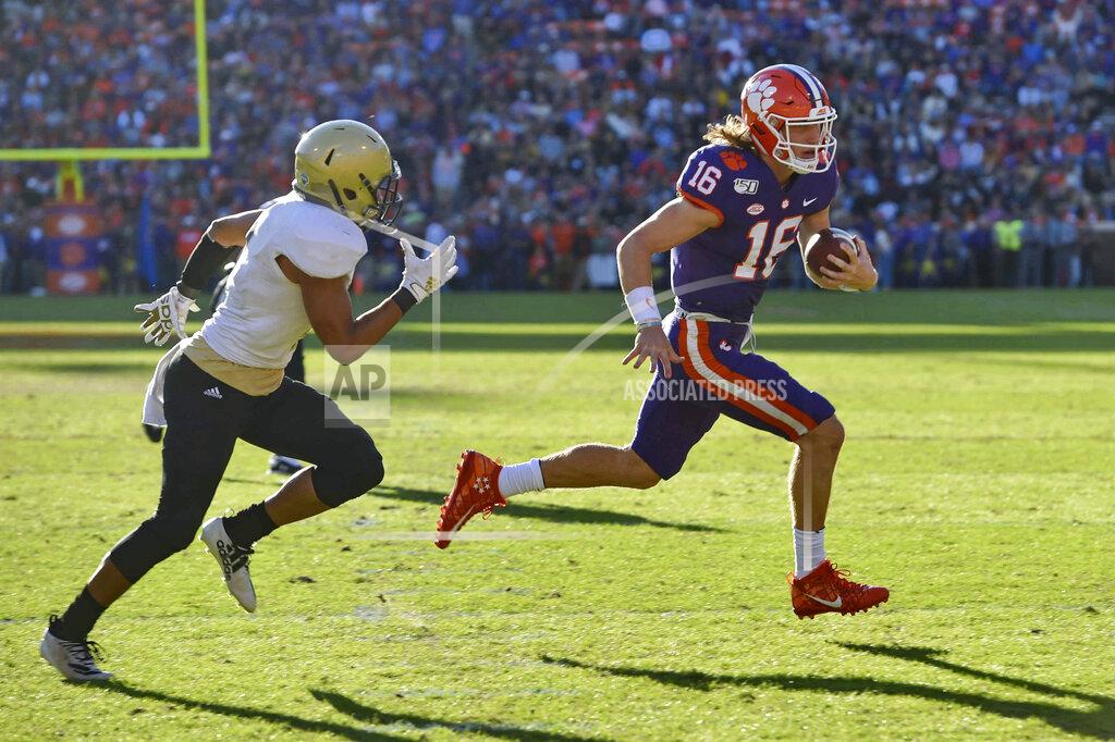 Richard Shiro Clemson quarterback Trevor Lawrence (16) runs on a quarterback-keeper for a touchdown while defended by Wofford's Keyvaun Cobb during the first half of an NCAA college football game, Saturday, Nov. 2, 2019, in Clemson, S.C. (AP Photo/Richard Shiro)
