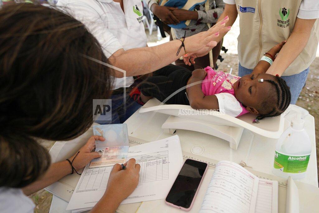 Fernando Vergara A young Haitian migrant is weighed by Colombia's Family Welfare Institute before boarding a boat to Acandi, near the border with Panama, from Necocli, Colombia, Monday, Sept. 13, 2021. Migrants have been gathering in Necocli as they move north on their way to the U.S. border. (AP Photo/Fernando Vergara)
