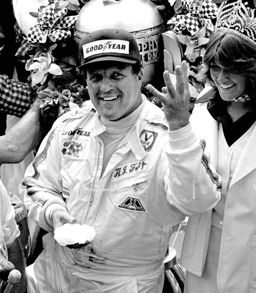 Anonymous FILE - In this May 29, 1977, file photo, driver A.J. Foyt holds up four fingers in victory lane after winning his fourth Indianapolis 500 auto race at Indianapolis Motor Speedway in Indianapolis. pedestrians in Gasoline Alley or stopping to sign autographs. Yes, things are definitely different at his favorite racing venue. Even the seemingly indestructible 85-year-old, four-time Indianapolis 500 winner finds himself reluctantly wearing a mask and social distancing. (AP Photo/File)