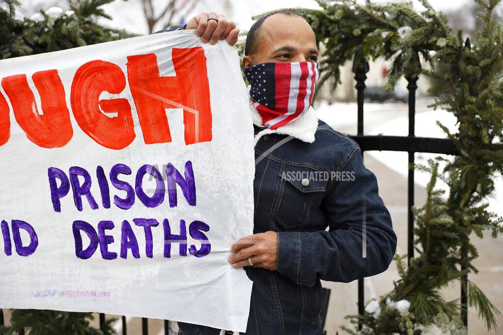 Coburn Dukehart Ramiah Whiteside of Milwaukee holds a sign during a protest outside of the Wisconsin governor's mansion in Maple Bluff, Wis., on Nov. 24, 2020. Event organizers sought to draw attention to the thousands of inmates and staff who have contracted COVID-19 in state prisons and called for Gov. Tony Evers to slow the spread of the disease by reducing overcrowding. Whiteside is prison outreach director for Milwaukee-based Ex-incarcerated People Organizing, which is part of Wisdom, a statewide faith-based prison advocacy group. (Coburn Dukehart/Wisconsin Watch via AP)