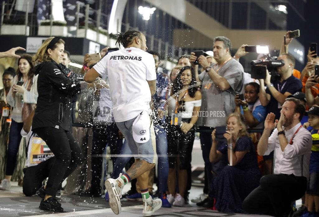 Mercedes driver Lewis Hamilton of Britain celebrates in the garage after winning the Emirates Formula One Grand Prix, at the Yas Marina racetrack in Abu Dhabi, United Arab Emirates, Sunday, Dec.1, 2019. (AP Photo/Luca Bruno)