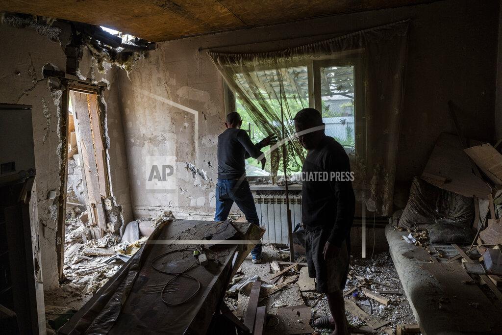 Bernat Armangue Yuri Kuzinskiy, right, and Alexey Goruliov remove debris moments after Kuzinskiy's house was bombed in Kharkiv, in eastern Ukraine, Friday, May 20, 2022. Kuzinskiy was sleeping on the couch when a shell hit his house. (AP Photo/Bernat Armangue)
