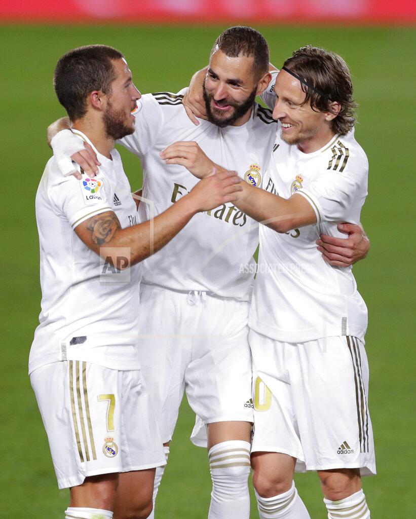 Manu Fernandez Real Madrid's Karim Benzema, center, celebrates with his teammates Eden Hazard, left, and Luka Modric after scoring his side's opening goal during the Spanish La Liga soccer match between Real Madrid and Valencia at Alfredo di Stefano stadium in Madrid, Spain, Thursday, June 18, 2020. (AP Photo/Manu Fernandez)