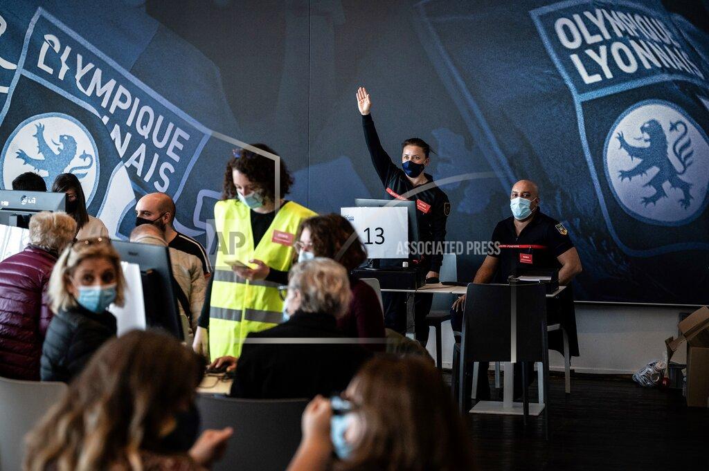 Jean-Philippe Ksiazek Firefighters welcome people to be vaccinated against Covid-19 on the opening day of a mass vaccination centre set up in the Olympique Lyonnais soccer Stadium, in Decines-Charpieu, Saturday, April 3, 2021. (Jean-Philippe Ksiazek, Pool via AP)