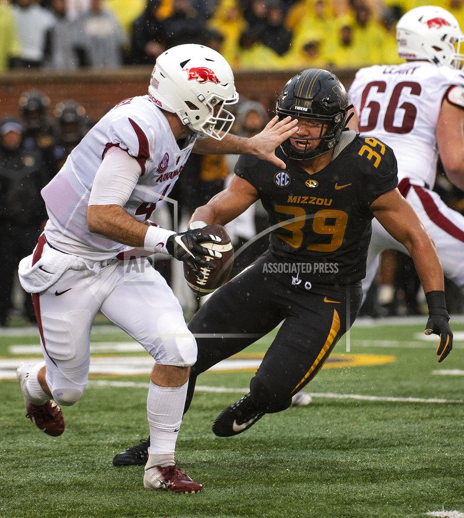 L.g. Patterson Arkansas quarterback Ty Storey, left, tries to avoid Missouri defensive lineman Chris Turner, right, during the first half of an NCAA college football game Friday, Nov. 23, 2018, in Columbia, Mo. (AP Photo/L.G. Patterson)