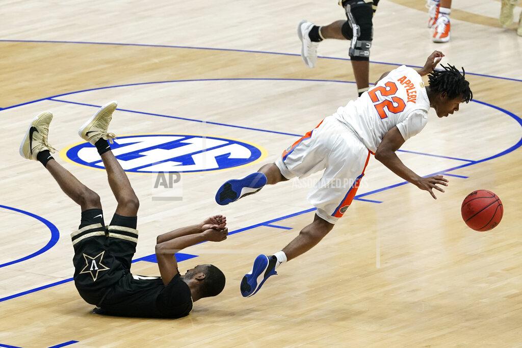 Mark Humphrey Florida's Tyree Appleby (22) falls over Vanderbilt's Trey Thomas, left, in the second half of an NCAA college basketball game in the Southeastern Conference Tournament Thursday, March 11, 2021, in Nashville, Tenn. (AP Photo/Mark Humphrey)