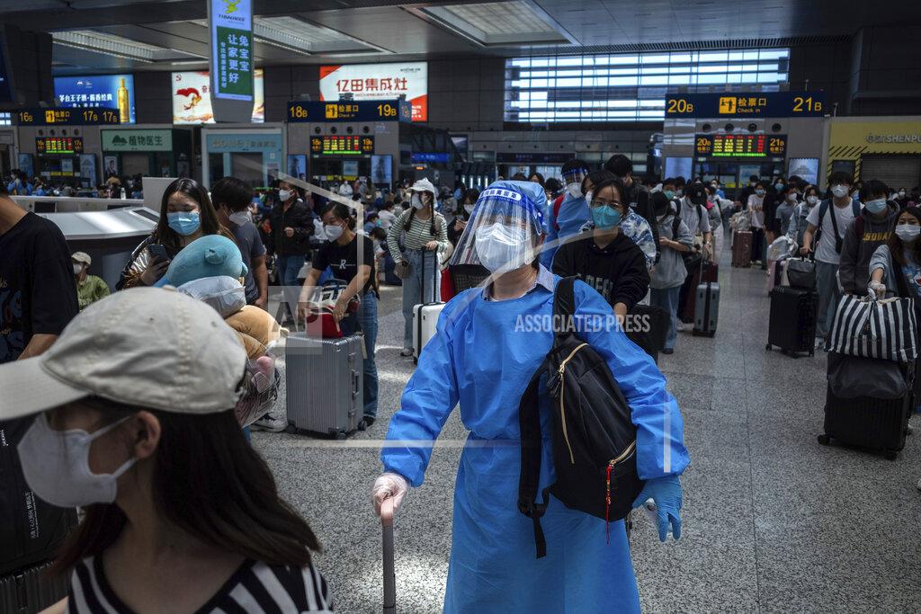 Uncredited A passenger in protective overall waits to board a train at the Hongqiao Railway Station in Shanghai, China Sunday, May 22, 2022. The locked-down Chinese metropolis of Shanghai opens some public transit services as it slowly eases pandemic restrictions that have kept most residents in their housing complexes for more than six weeks. (Chinatopix via AP)