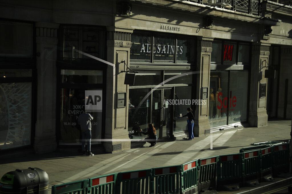 Matt Dunham Staff prepare the front window of the AllSaints clothing store on Regent Street, in London, ahead of non-essential shops being allowed to open again tomorrow as England's second coronavirus lockdown is due to end, Tuesday, Dec. 1, 2020. In another dark day for the British retailing industry, Debenhams said Tuesday it will start liquidating its business after a potential buyer of the company pulled out, a move that looks like it will cost 12,000 workers their jobs. (AP Photo/Matt Dunham)