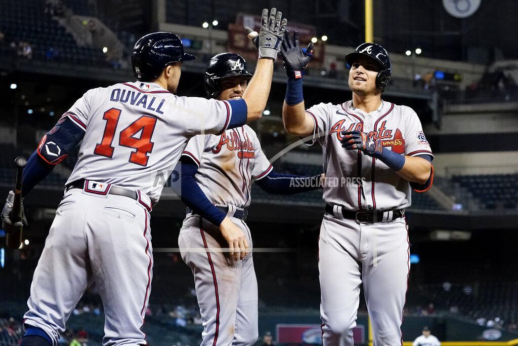 Matt York Atlanta Braves Austin Riley, right, high fives Adam Duvall (14) as Freddie Freeman looks on after hitting a two run home run during the first inning of a baseball game against the Arizona Diamondbacks, Tuesday, Sept. 21, 2021, in Phoenix. (AP Photo/Matt York)