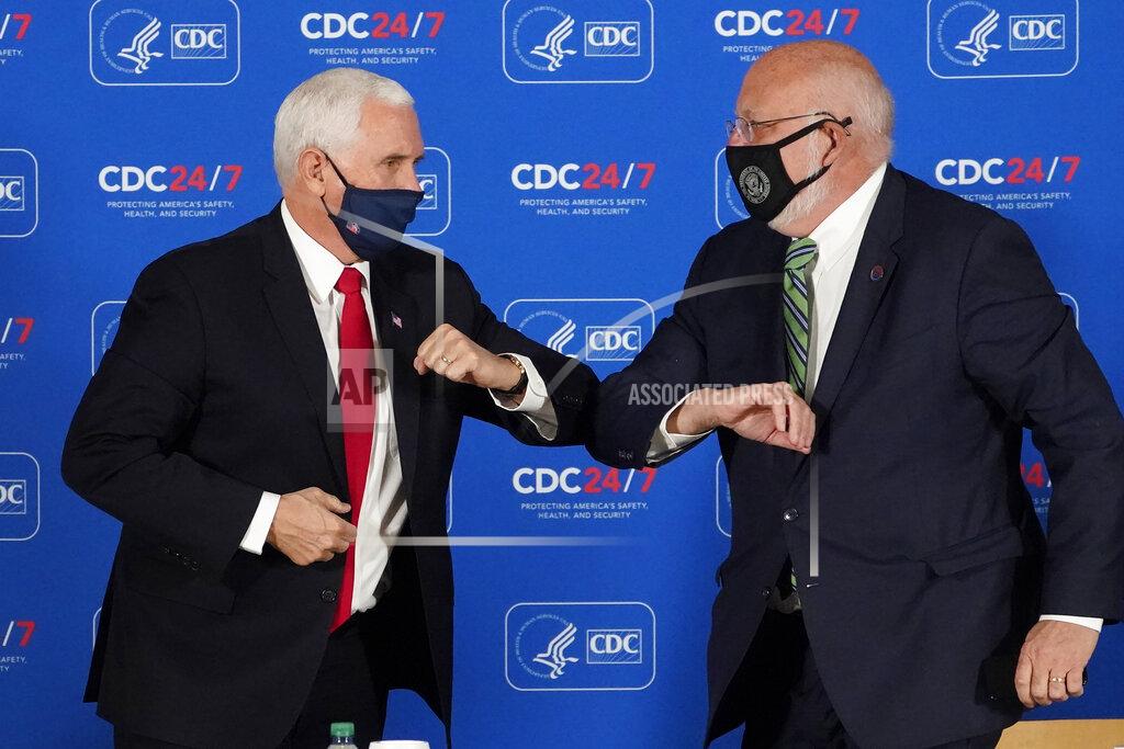 John Bazemore Vice President Mike Pence, left, and Centers for Disease Control and Prevention director Dr. Robert Redfield exchange elbow bumps after a briefing at the CDC Friday, Dec. 4, 2020, in Atlanta. (AP Photo/John Bazemore)