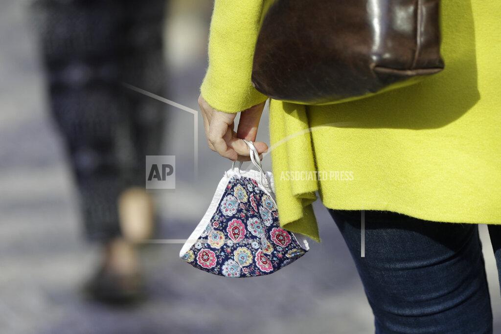 Petr David Josek A woman carries a face mask in Prague, Czech Republic, Monday, Sept. 21, 2020. The country coped well with the first wave of the coronavirus infections in the spring but has been facing a record surge of the new confirmed cases last week. (AP Photo/Petr David Josek)