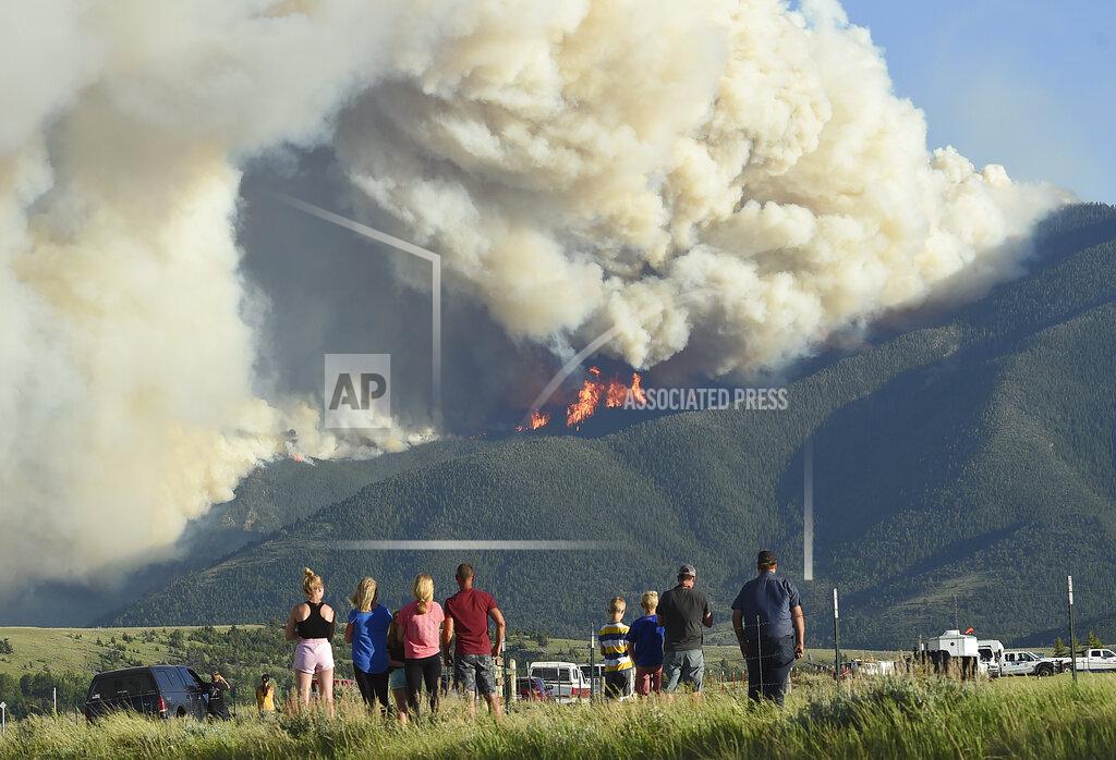 Larry Mayer Residents watch as flames from the Robertson Draw fire burn above Red Lodge, Mont., Tuesday evening, June 15, 2021. Wildfires burning in Montana exploded in size over the past 24 hours and triggered evacuations of people from rural areas as scorching heat and heavy winds stoked the blazes. (Larry Mayer/The Billings Gazette via AP)