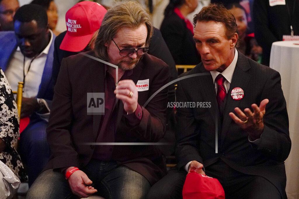 Brynn Anderson Singer Travis Tritt, left, speaks with former NFL football player Doug Flutie during an election night watch party for U.S. Senate candidate Herschel Walker, Tuesday, May 24, 2022, in Atlanta.(AP Photo/Brynn Anderson)