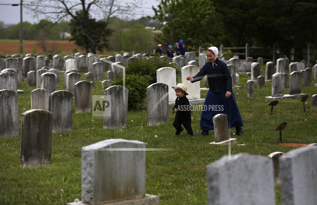 Jessie Wardarski In this Sunday, May 17, 2020, photo, two children of the old Order Stauffer Mennonite Church run through a cemetery located next to the congregation's church in New Holland, Pa. After complying with Gov. Tom Wolf's stay-at-home order for nearly two months, the ministry and its over 200 parishioners have begun gathering for worship once again. (AP Photo/Jessie Wardarski)