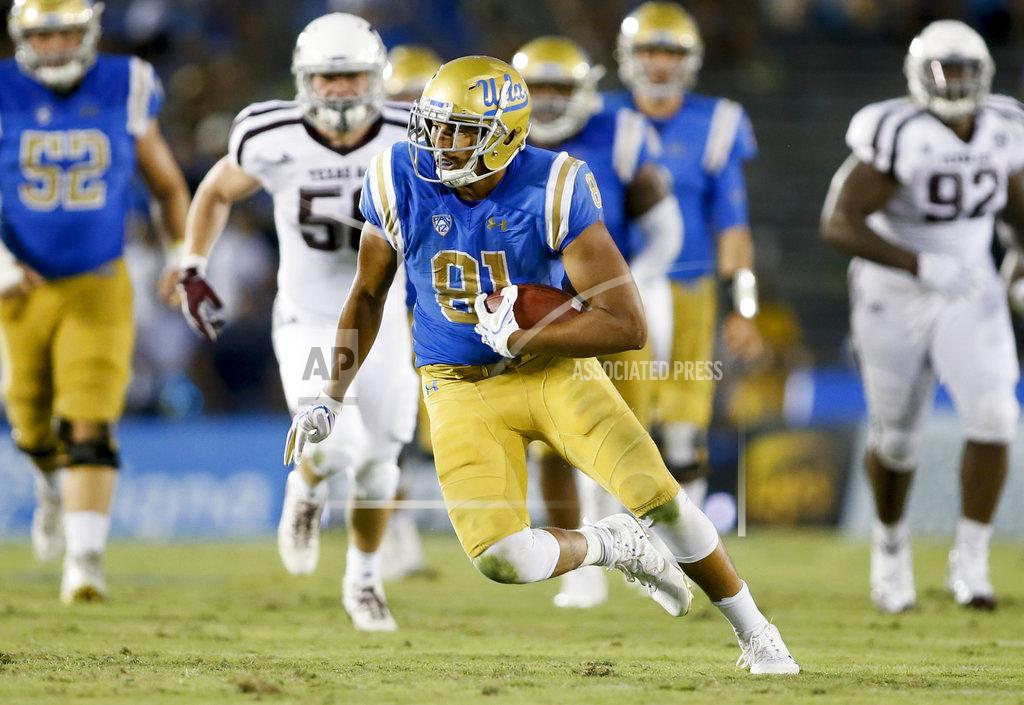 FILE - In this Sept. 3, 2017, file photo, UCLA tight end Caleb Wilson runs with the ball against Texas A&M during an NCAA college football game in Pasadena, Calif. Wilson had 38 caches for 490 yards in only five games last season before a foot injury shut him down for the rest of the year. (AP Photo/Danny Moloshok, File)