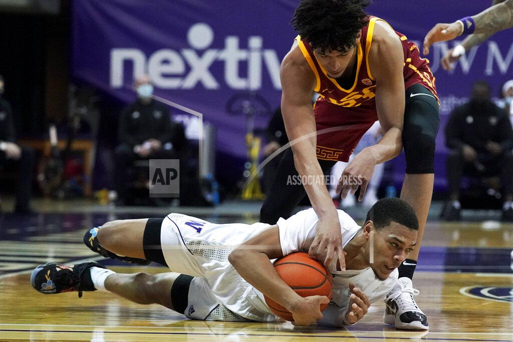 Ted S. Warren Washington guard Quade Green, bottom, holds on to the ball as Southern California forward Max Agbonkpolo, top, reaches for it during the first half of an NCAA college basketball game Thursday, Feb. 11, 2021, in Seattle. (AP Photo/Ted S. Warren)