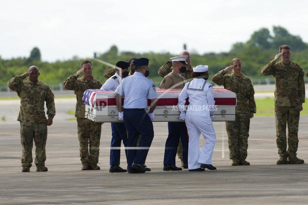 Sakchai Lalit U.S. military salute the possible remains of a WWII U.S. airman found in northern Thailand to a waiting C-17 during a repatriation ceremony Wednesday, May 18, 2022, at the U-Tapao Air Base in Rayong province, eastern Thailand. The possible human remains were found at a crash site in a rice field in northern Thailand by the Defense POW/MIA Accounting Agency and were sent to Hawaii where they will be tested to see if they belong to a U.S. pilot who went missing in 1944. (AP Photo/Sakchai Lalit)