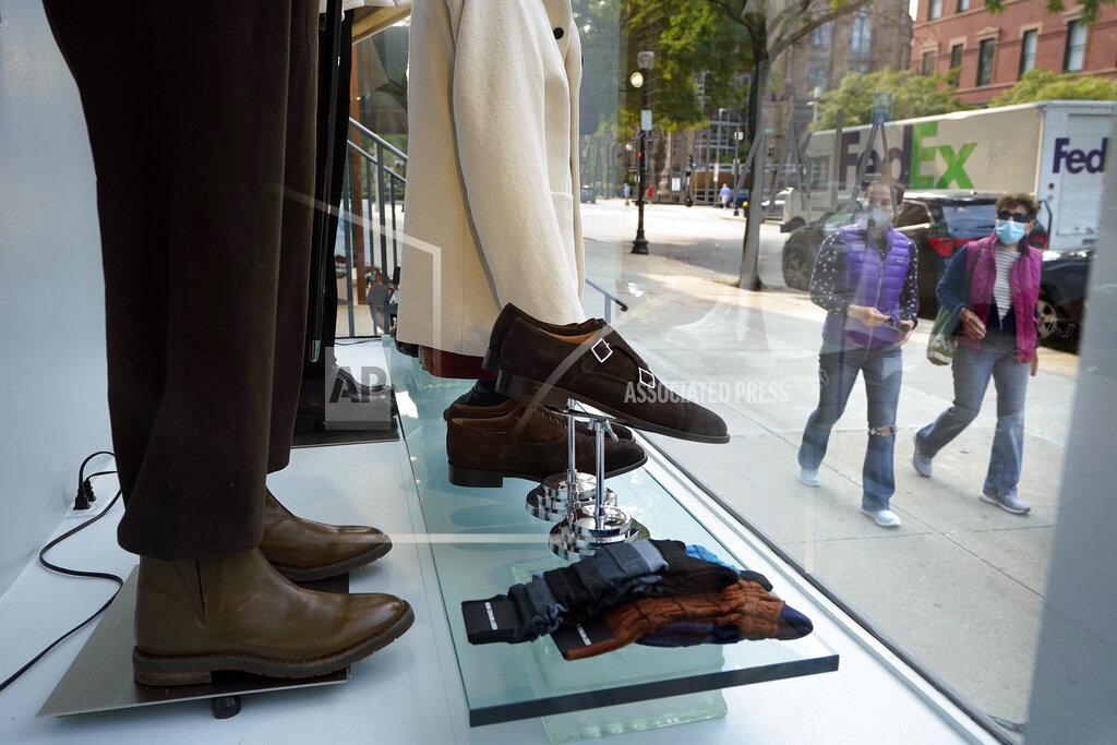 Steven Senne FILE - In this Sept. 15, 2020, file photo, people examine a storefront window as they walk in Boston's fashionable Newbury Street shopping district. Defying fears of another slowdown, U.S. businesses kept hiring at a solid pace in October yet there are signs they remain cautious about the economy's future as the pandemic worsens. (AP Photo/Steven Senne, File)