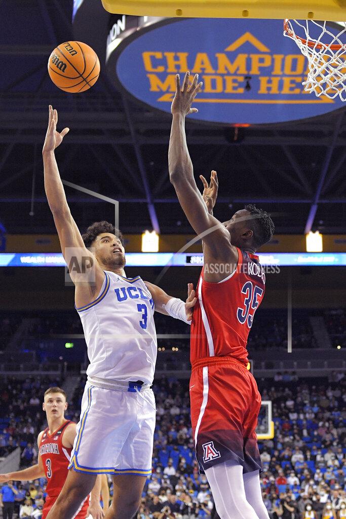 Mark J. Terrill UCLA guard Johnny Juzang, left, shoots as Arizona center Christian Koloko defends during the first half of an NCAA college basketball game Tuesday, Jan. 25, 2022, in Los Angeles. (AP Photo/Mark J. Terrill)