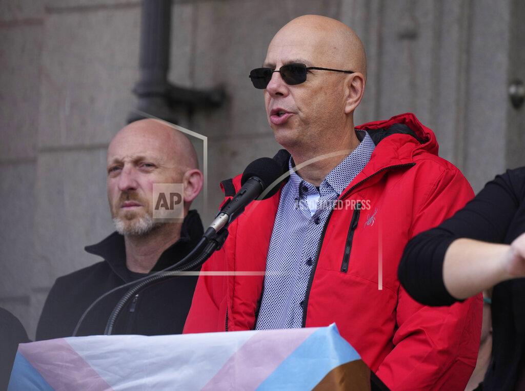 David Zalubowski Co-owners of Club Q, Matthew Haynes, front, and Nic Grzecka, address the crowd after a 25-foot historic pride flag was displayed on the exterior of City Hall to mark the weekend mass shooting at the gay nightclub Wednesday, Nov. 23, 2022, in Colorado Springs, Colo. The flag, known as Section 93 of the Sea to Sea Flag, is on loan for two weeks to Colorado Springs from the Sacred Cloth Project. (AP Photo/David Zalubowski)